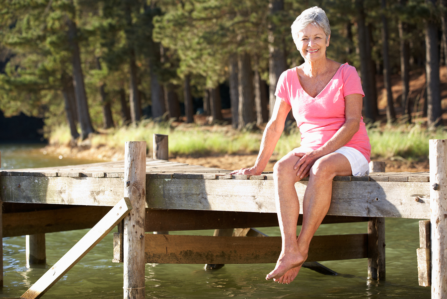 Senior Woman Sitting By Lake