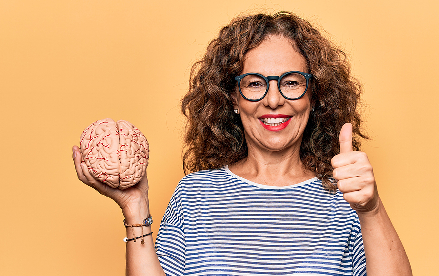 Middle Age Brunette Woman Holding Brain As Mental Care And Memor