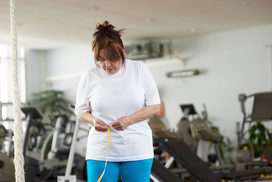 Senior Woman With Measuring Tape At Gym. Older Caucasian Woman M