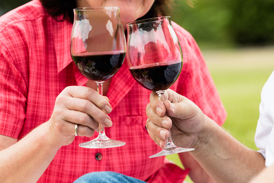 Close Up Of Senior Couple Toasting Glass Of Wine