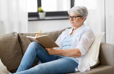 Age, Leisure And People Concept Happy Senior Woman Writing To