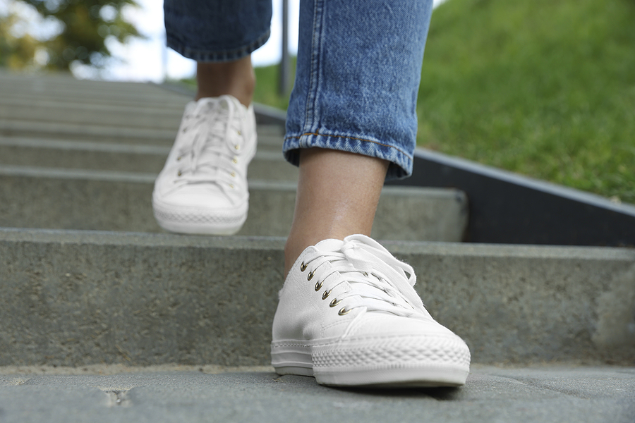 Woman In Stylish Black Sneakers Walking Down Stairs, Closeup