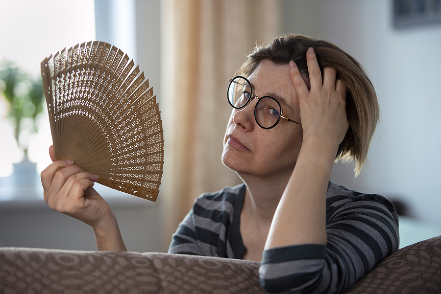 Exhausted Middle Aged Woman Waving Her Fan, Suffering From Menop