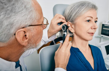Otolaryngologist Doctor Checking Senior Womans Ear Using Otoscop